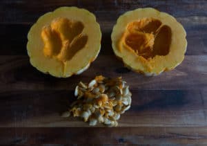 Squash/ pumpkin cut around the equator and seeds scooped out. Ready for seasoning and roasting.