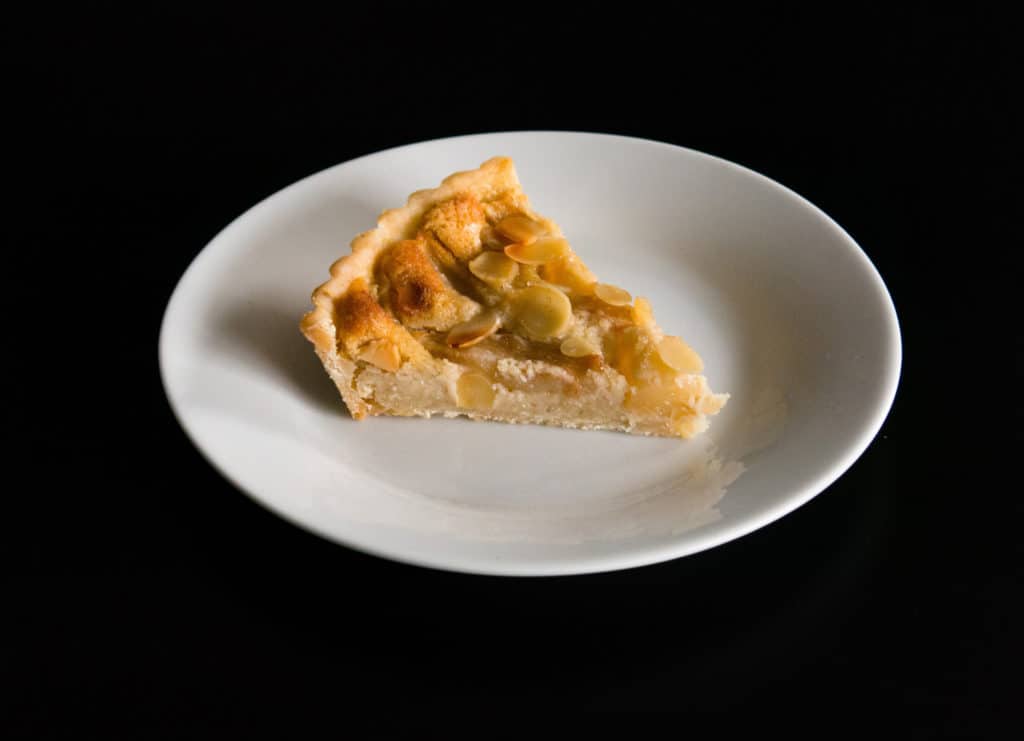 Slice of gluten free, vegan Pear Frangipane Tart. Delicious autumn dessert.