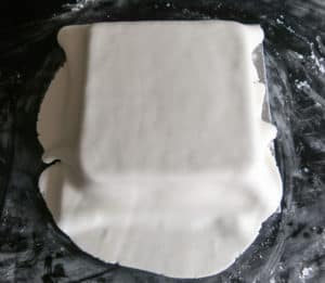 Gluten free, vegan Christmas cake with icing layer placed on top. Ready to be shaped around cake