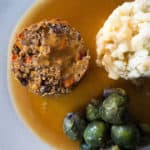 Gluten free, vegan haggis with mashed potatoes, purple sprouts and gravy